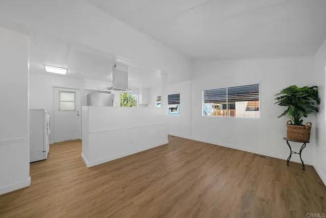a view of a kitchen with wooden floor and a window