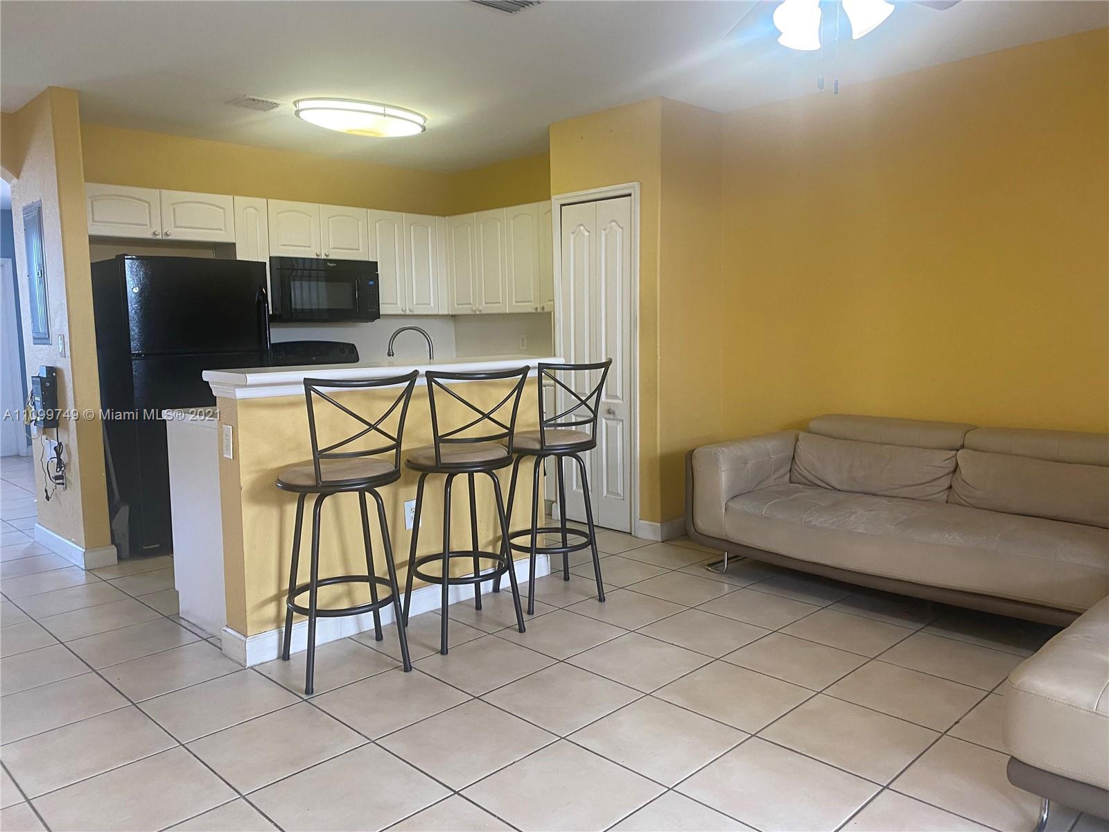 Hialeah Hialeah, FL 33018 - Photo 8 of 27 a living room with furniture a flat screen tv and kitchen view