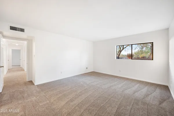 a view of an empty room with a fireplace and a window