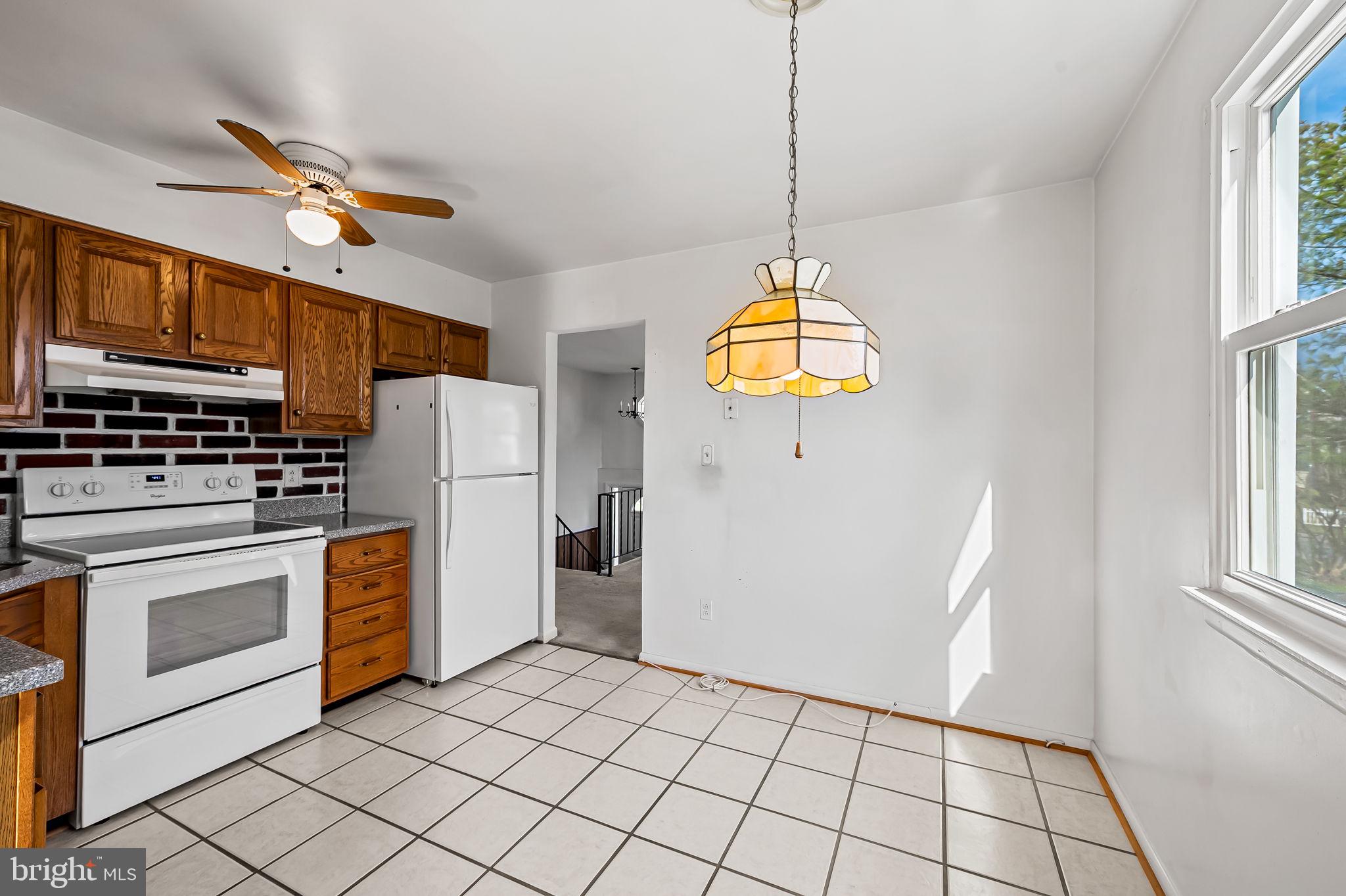 9382 North Laurel Road Laurel, MD 20723 - Photo 7 of 31 a kitchen with stainless steel appliances granite countertop a refrigerator a stove a sink dishwasher and a dining table with wooden floor