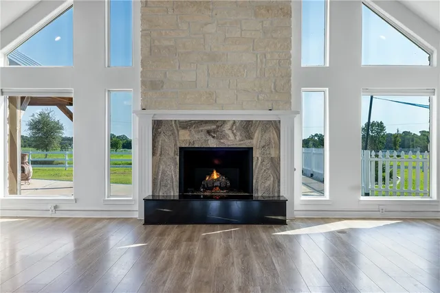 a living room with a fireplace and a floor to ceiling window