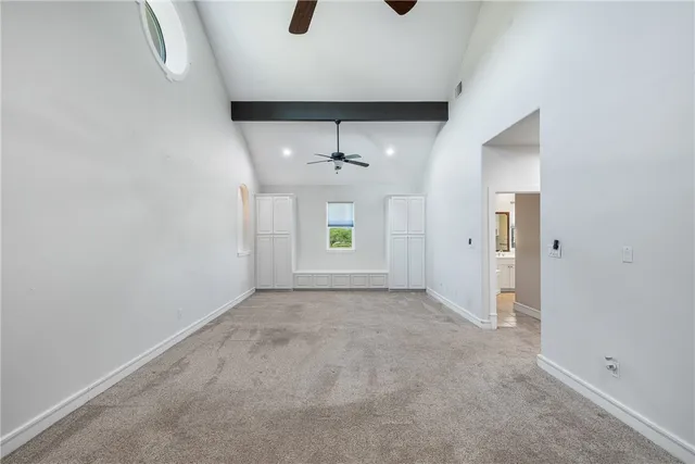 an empty room with windows and cabinet