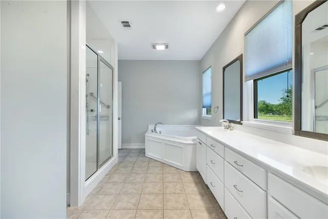 a spacious bathroom with a bathtub sink and mirror