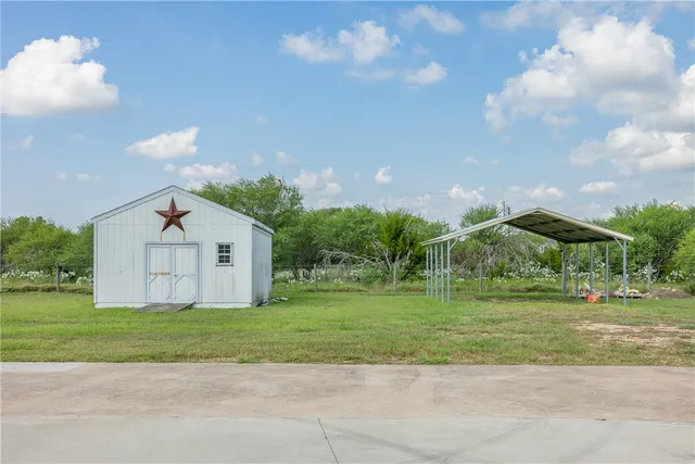 a view of a house with a big yard and large trees