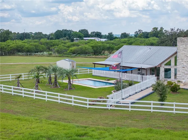 a view of a house with a big yard and potted plants