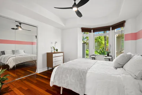 a bedroom with a bed next to a large window with the outer view