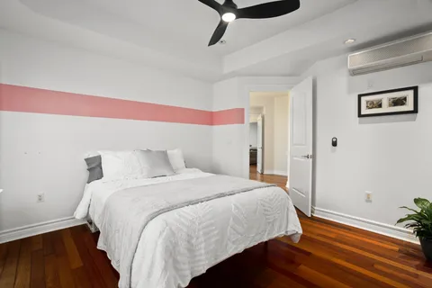 a bedroom with a bed and wooden floor