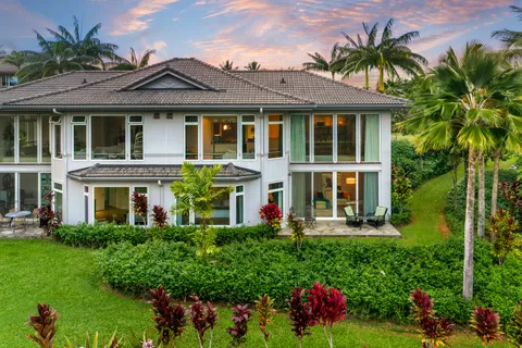 a front view of a house with a yard and potted plants