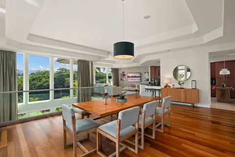 a dining room with furniture a large window and wooden floor