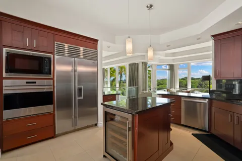 a kitchen with stainless steel appliances granite countertop a refrigerator a stove a sink and a microwave