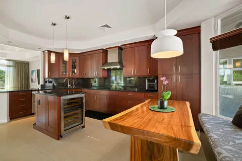 a kitchen with stainless steel appliances kitchen island granite countertop a table and chairs in it