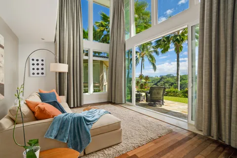 a living room with furniture and a large window with garden view