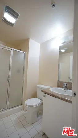 a bathroom with a granite countertop sink mirror vanity and toilet