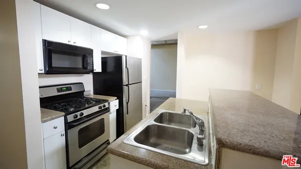 a kitchen with a sink stove and refrigerator