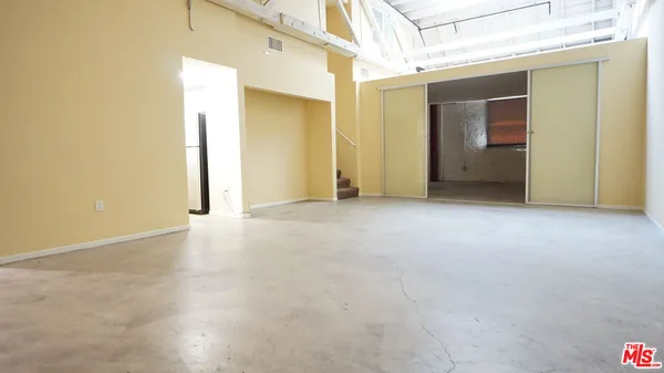 a view of an empty room with closet and a window