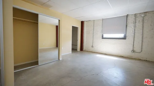 an empty room with windows and closet
