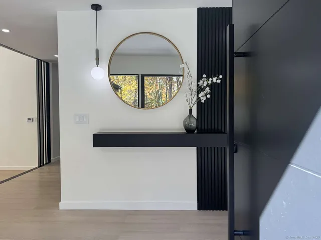 an empty room with wooden floor and mirror