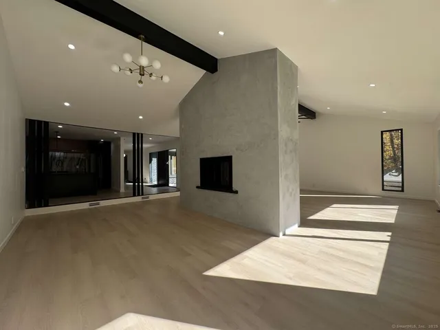 a view of an empty room with a fireplace and a window