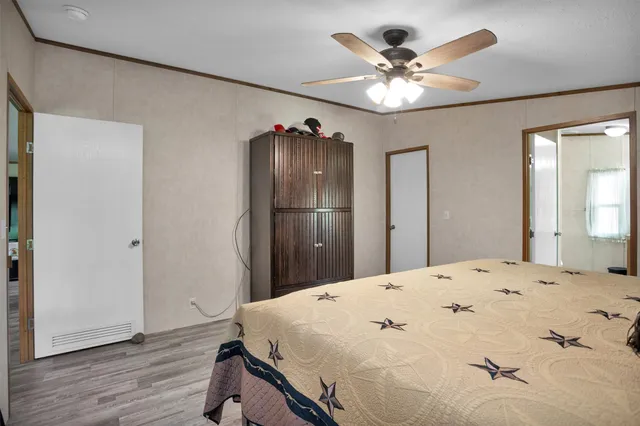 a very nice looking bedroom with a large bed and chandelier fan