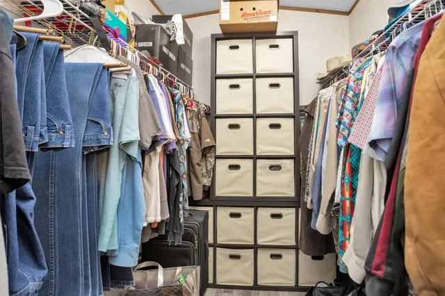 a view of walk in closet with clothes