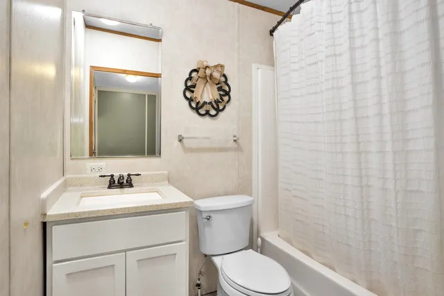 a bathroom with a toilet sink vanity and mirror