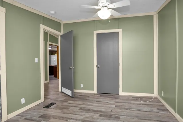 a view of an empty room with wooden floor
