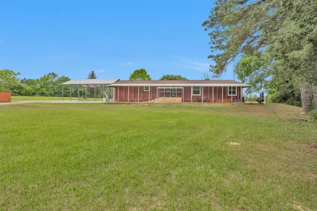 a view of a house with a yard and sitting area