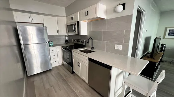 a kitchen with stainless steel appliances a refrigerator stove microwave and sink