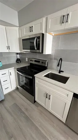 a kitchen with stainless steel appliances granite countertop a sink and a stove top oven