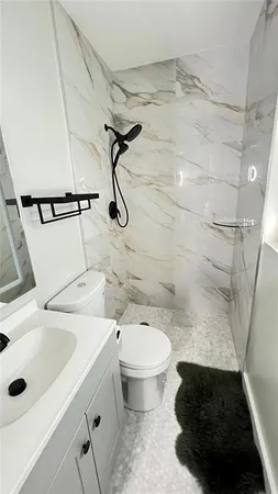 a bathroom with a sink a toilet and shower