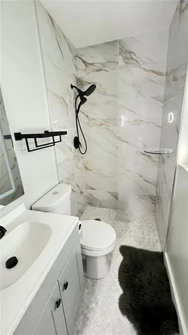 a bathroom with a sink a toilet and shower
