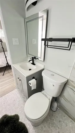 a bathroom with a toilet sink and mirror