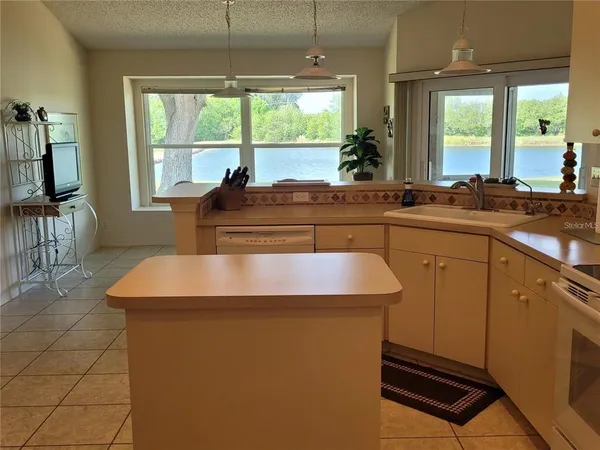 a kitchen with sink a window and chairs