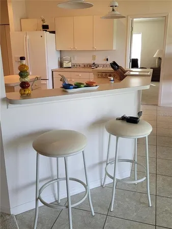 a kitchen with stainless steel appliances a sink a table and chairs in it