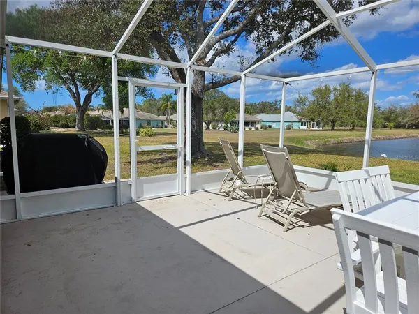 a view of a patio with a table chairs and a floor to ceiling window