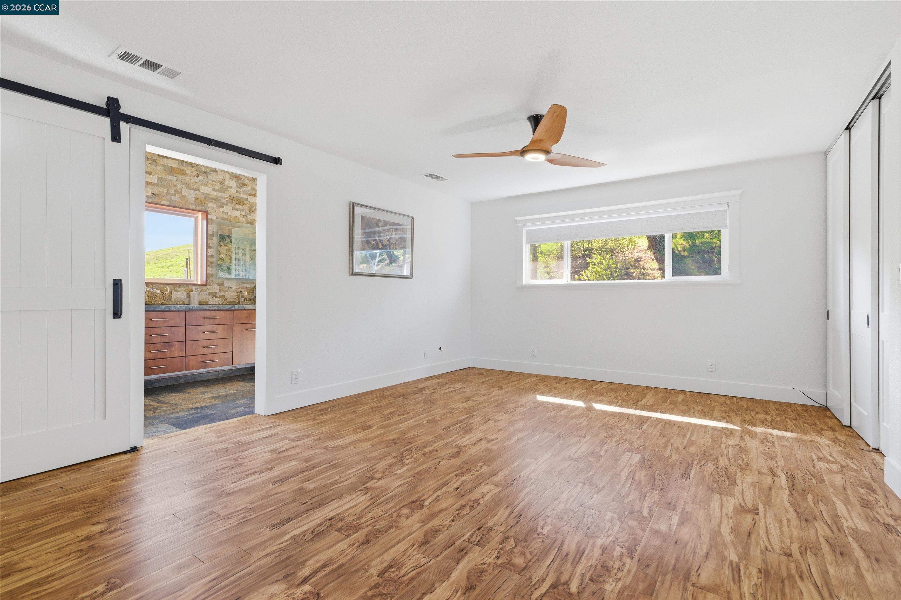 9530 Morgan Territory Road Livermore, CA 94551 - Photo 17 of 55 a view of an empty room with wooden floor and a window