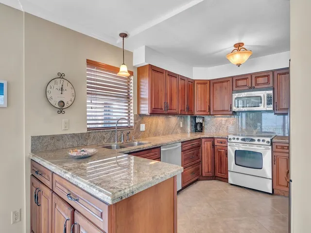 a kitchen with a stove a sink and chandelier