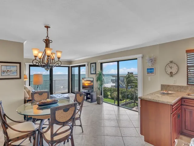 a living room with furniture a flat screen tv and a floor to ceiling window