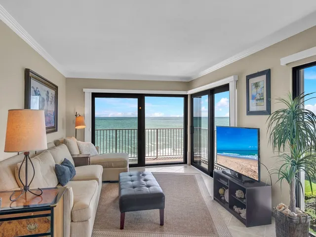 a living room with furniture and a floor to ceiling window