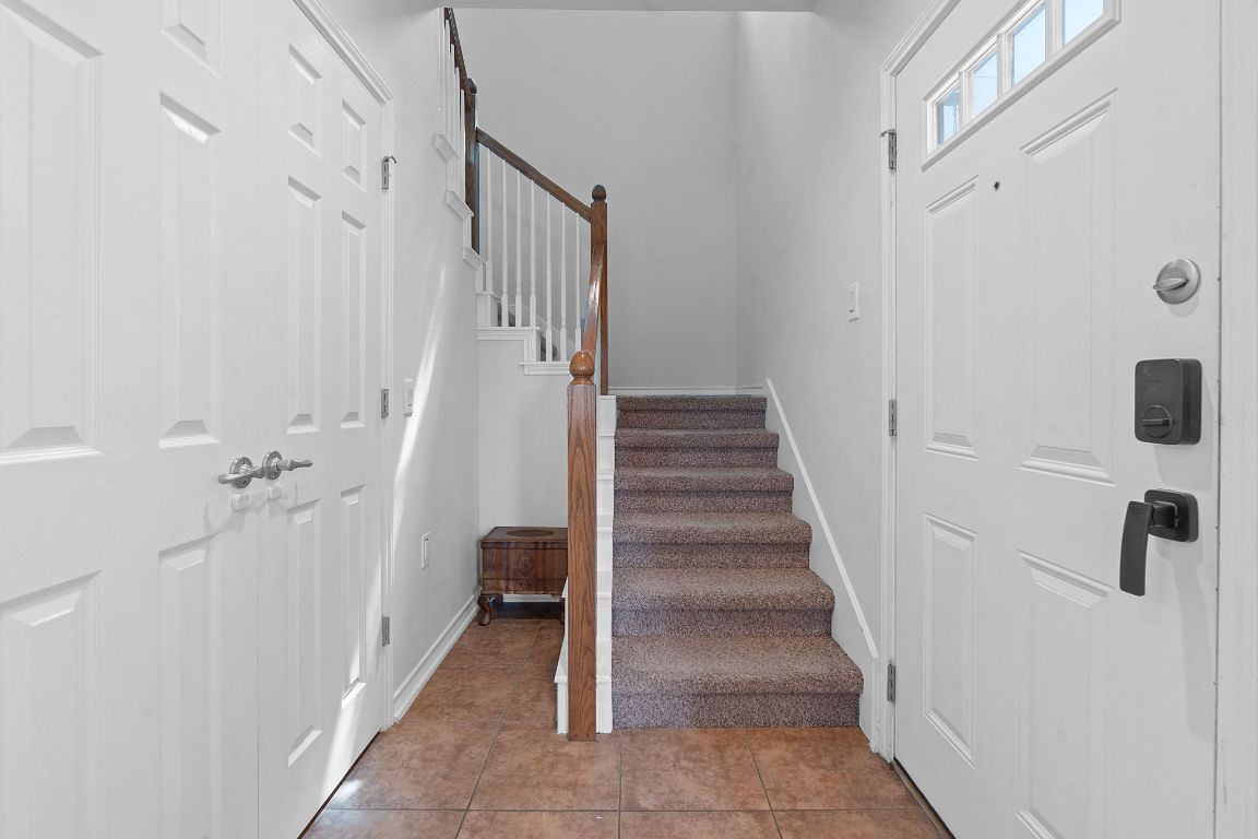 10700 Macmora Road, Unit 116 Austin, TX 78758 - Photo 14 of 26 Stairway with tile patterned flooring and baseboards