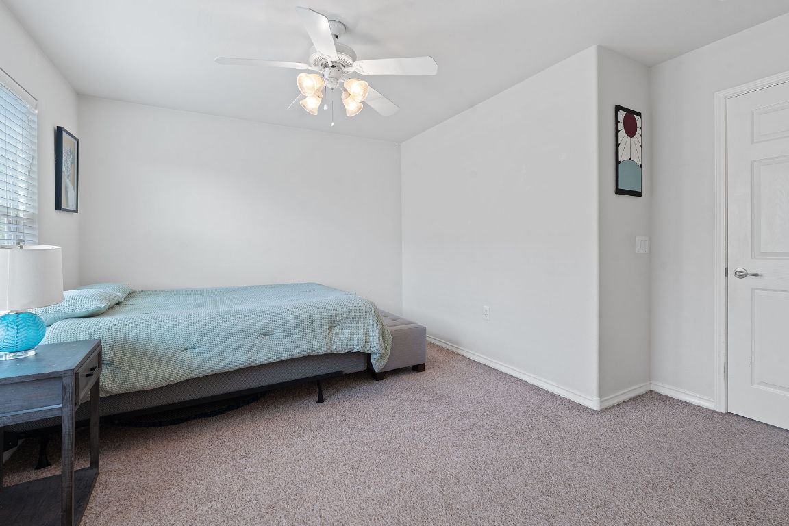 10700 Macmora Road, Unit 116 Austin, TX 78758 - Photo 15 of 26 Bedroom featuring carpet floors and a ceiling fan
