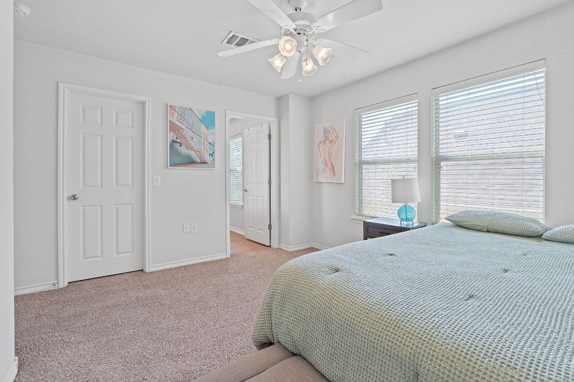 10700 Macmora Road, Unit 116 Austin, TX 78758 - Photo 17 of 26 Carpeted bedroom with multiple windows and a ceiling fan