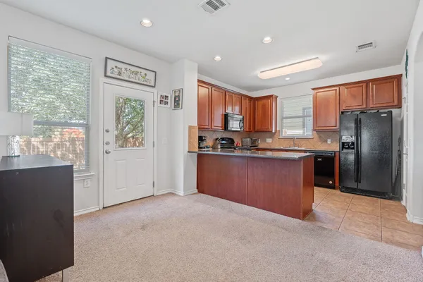 a kitchen with stainless steel appliances granite countertop a refrigerator and a stove top oven