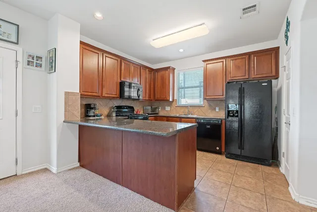 a kitchen with stainless steel appliances granite countertop a refrigerator stove and oven