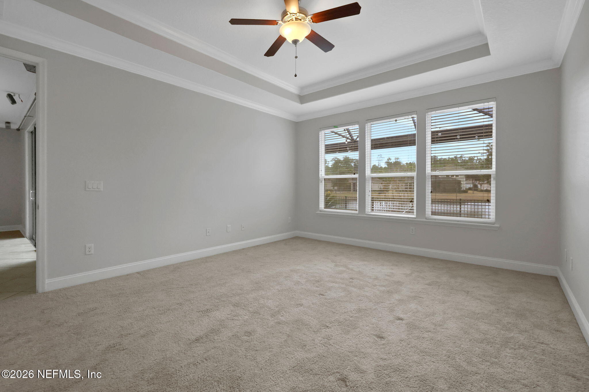 182 St Kitts Loop St. Augustine, FL 32092 - Photo 38 of 71 an empty room with a chandelier fan and windows