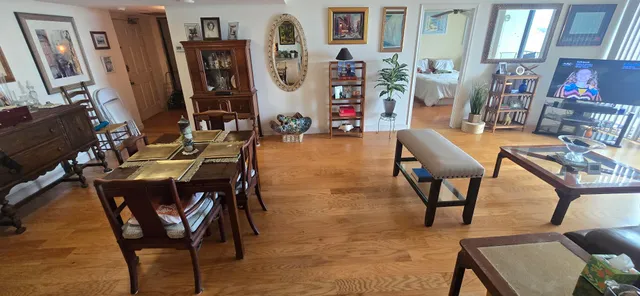 a living room with furniture a large window and wooden floor