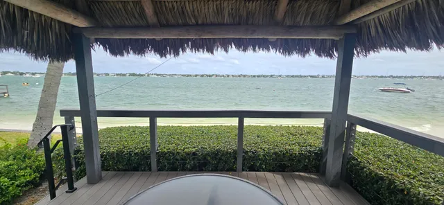 a view of swimming pool with outdoor seating and lake in the background