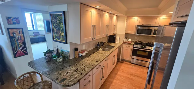 a kitchen with white cabinets and black appliances