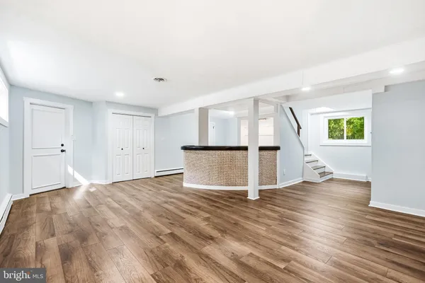 a view of empty room with wooden floor and window