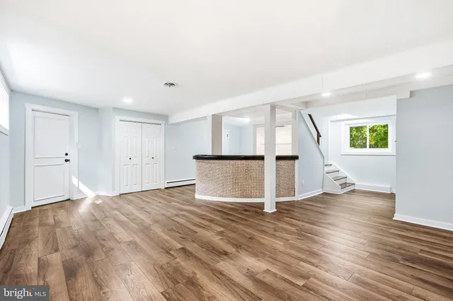 a view of empty room with wooden floor and window